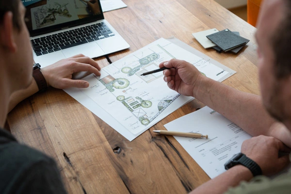 Planungsentwurf Gartengestaltung am Tisch zwischen zwei Männern